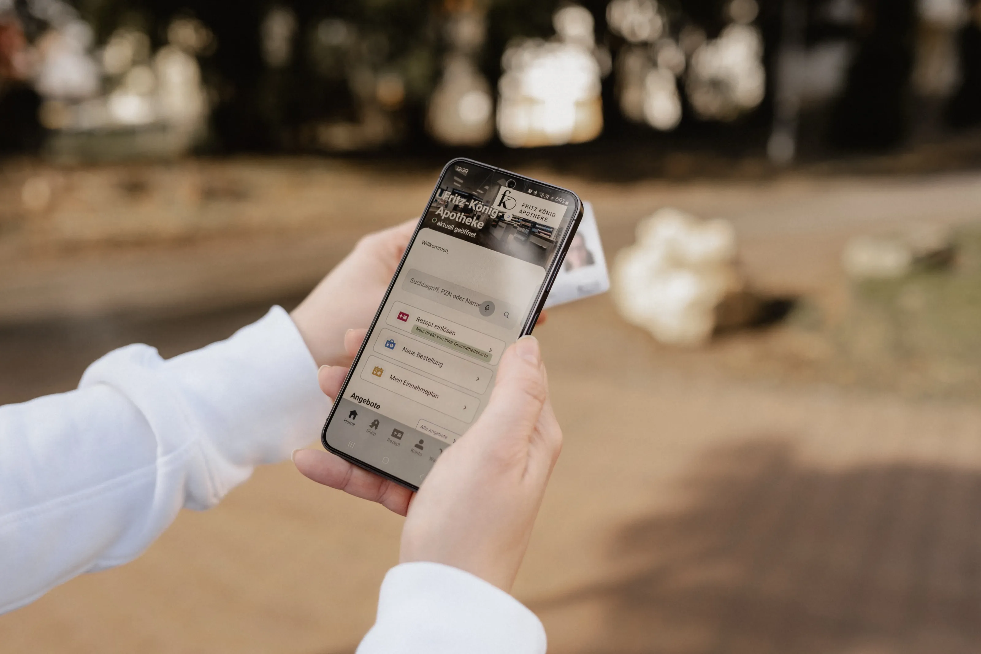 Hände halten ein Smartphone mit geöffneter Apotheken-App