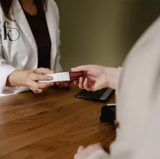 Am Tresen der Apotheke wird eine Medikamentenpackung über den Tisch gereicht