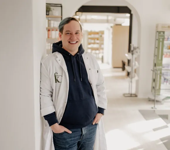 Philipp Steinecke lehnt lachend an einer Wand in der Offizin