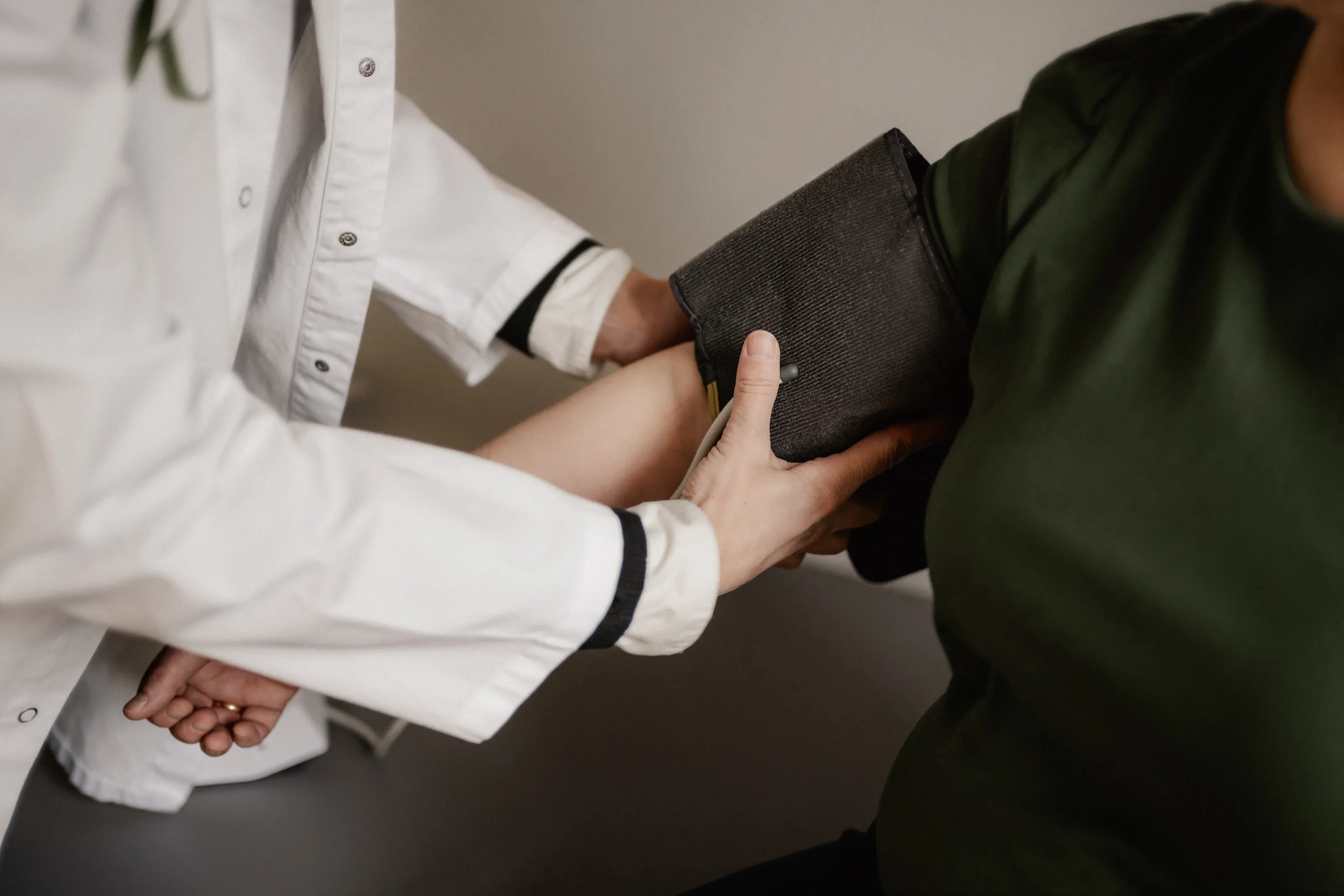 Eine Mitarbeiterin legt die Blutdruckmanschette am Oberarm an